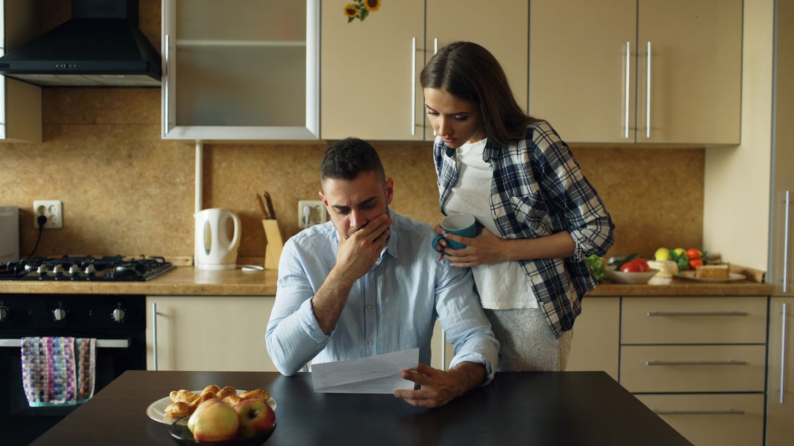 Older veteran couple comparing SSDI and VA disability benefit documents for a mesothelioma claim at home