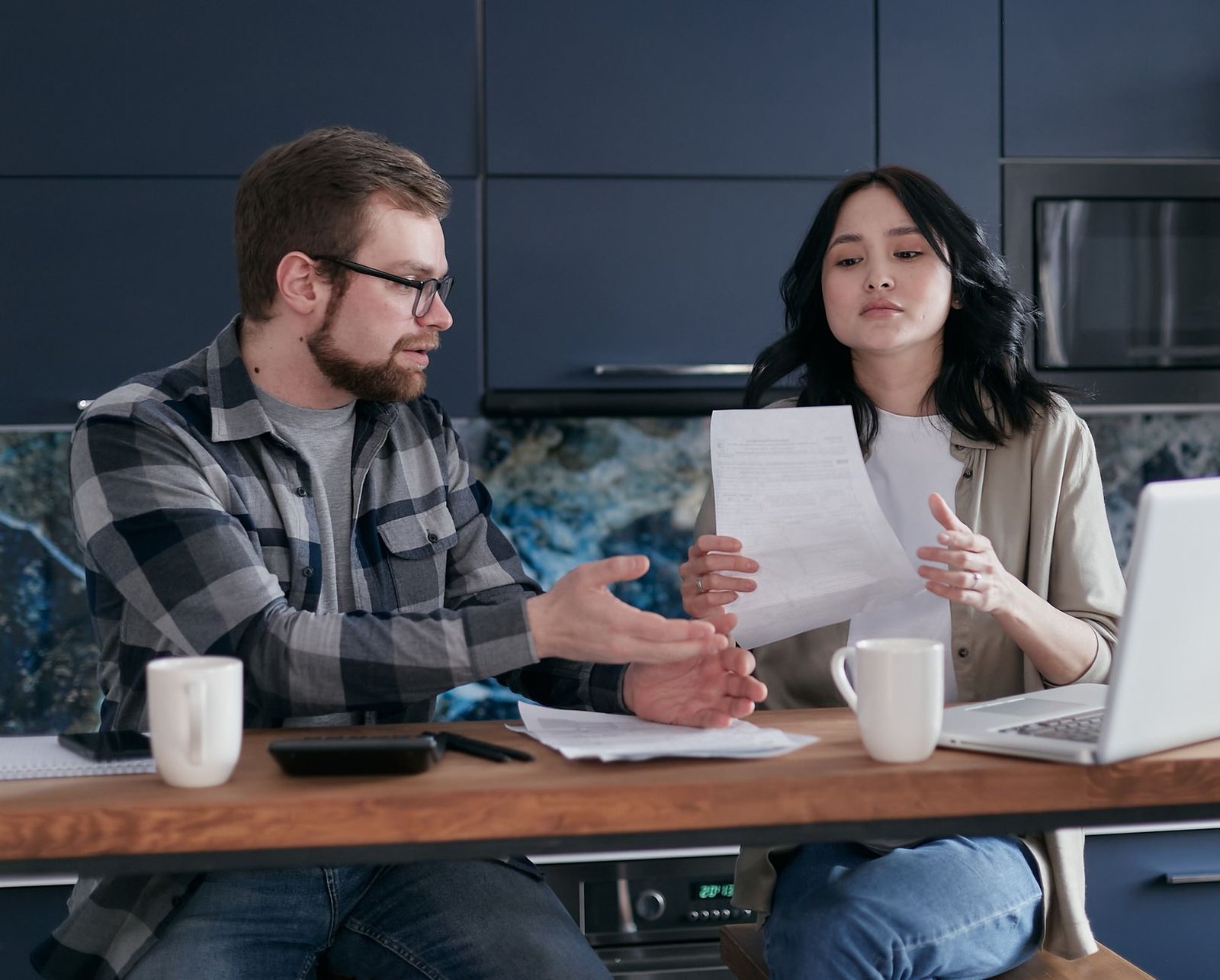 A veteran and his spouse comparing Medicare and VA health benefits paperwork at home
