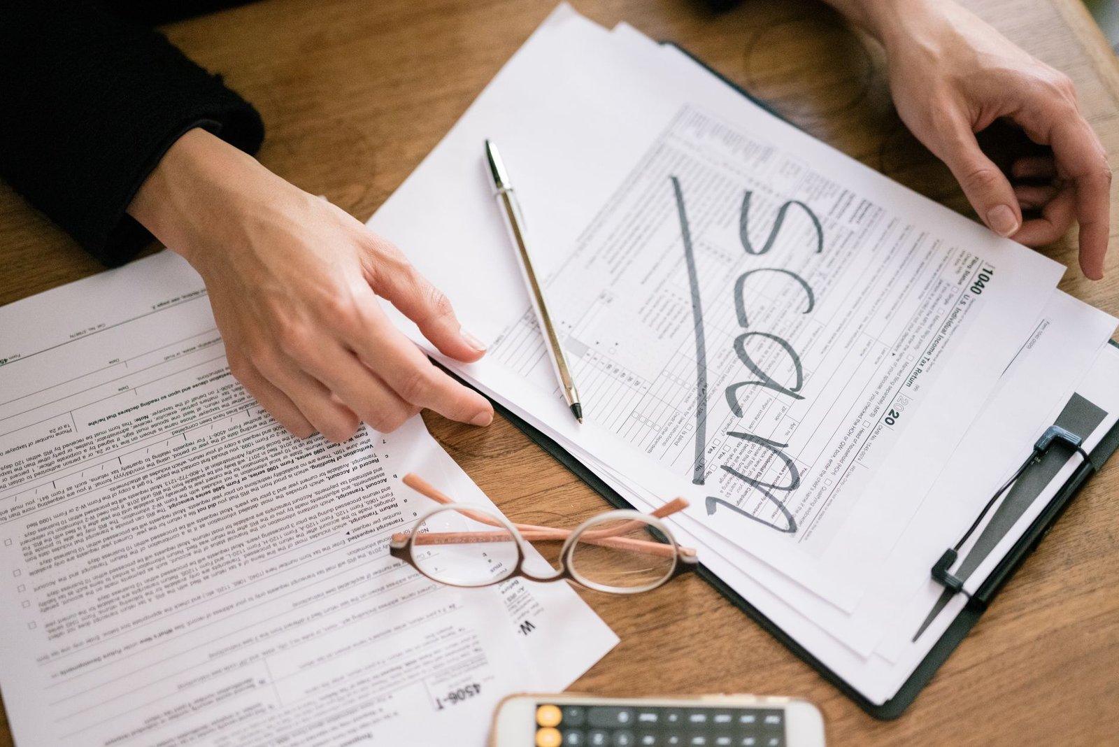 Hands completing a financial status report for a VA overpayment waiver request