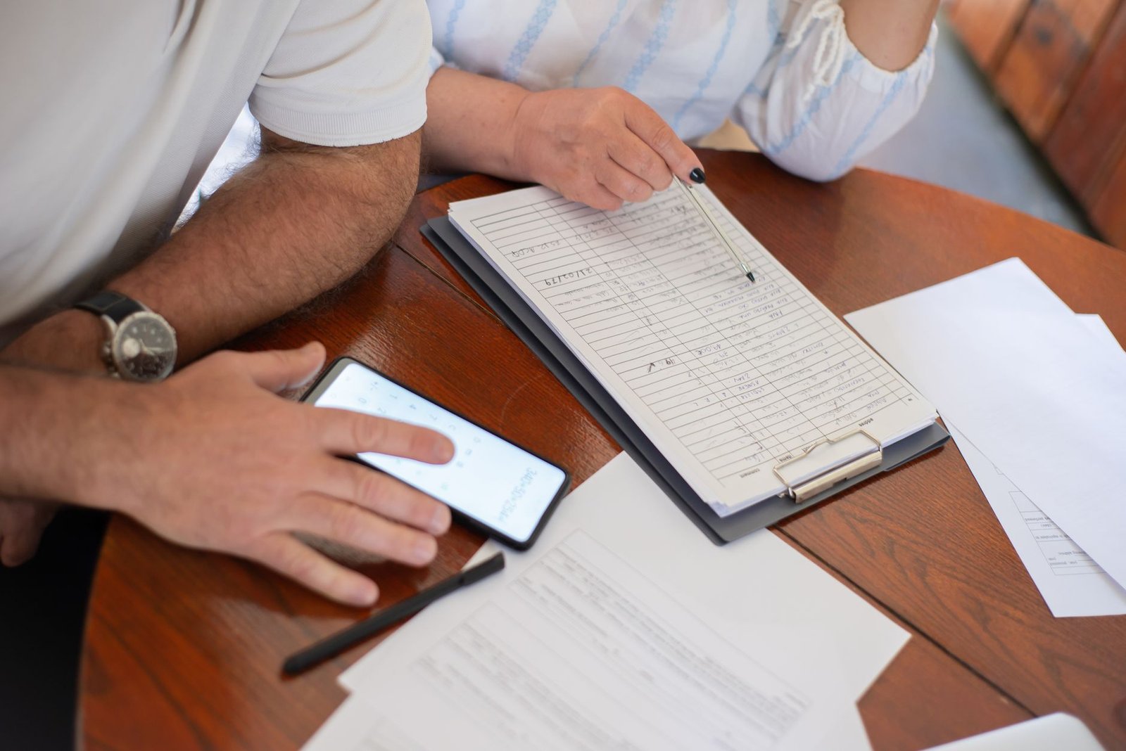 Older couple comparing VA pension and disability compensation figures at their kitchen table