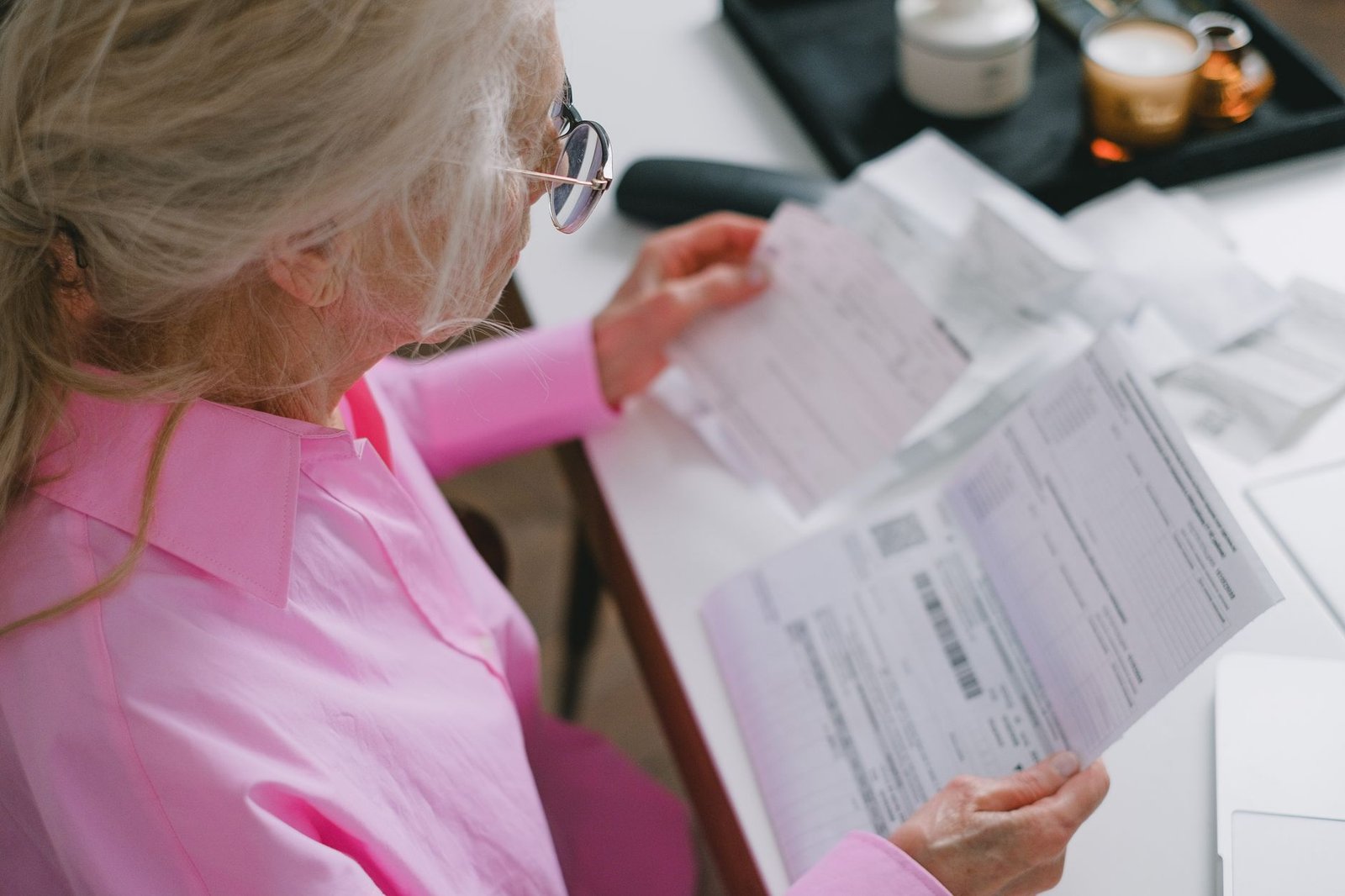 Surviving spouse reviewing VA Survivors Pension paperwork at her kitchen table