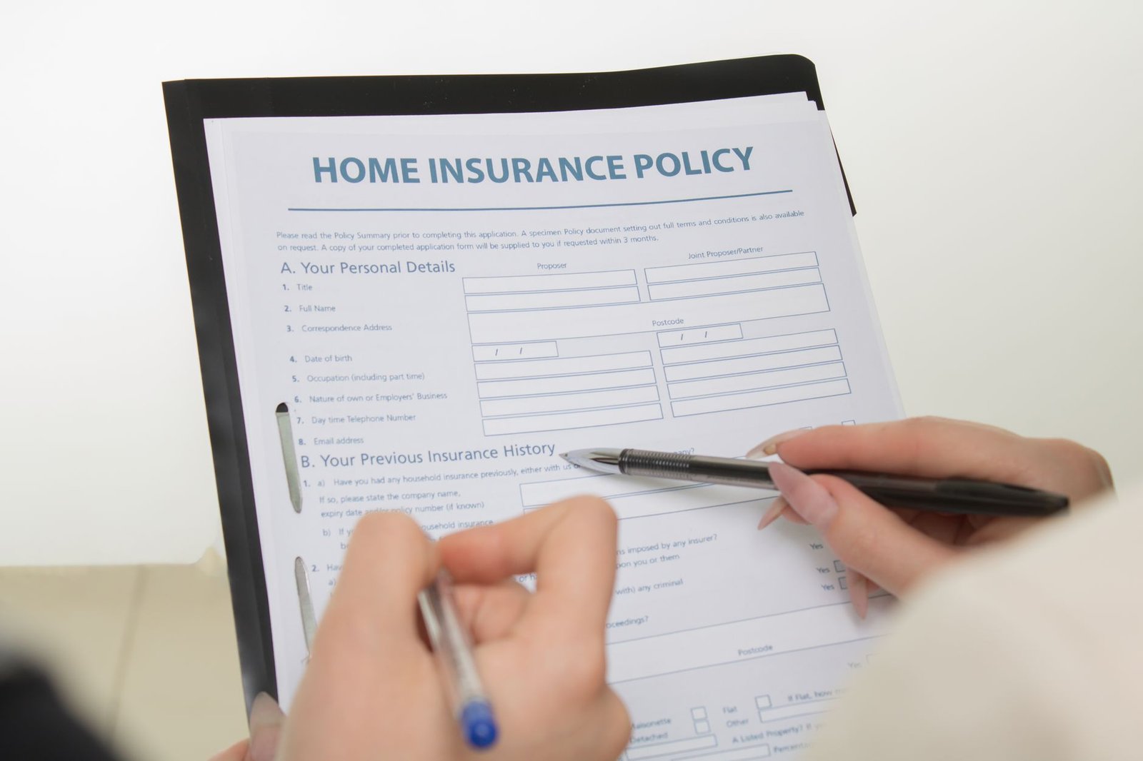 Hands completing forms related to VA emergency room coverage and hospital billing