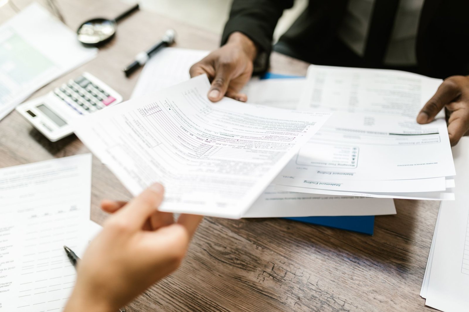 Veteran's hands completing claim forms to request a higher VA disability rating