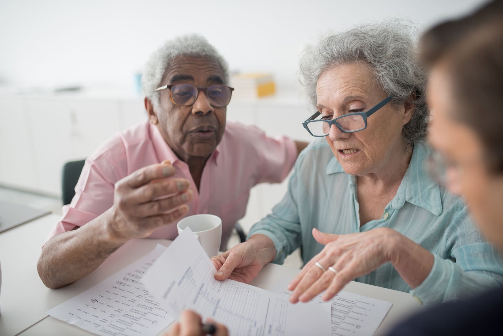 Older veteran discussing VA secondary conditions to mesothelioma with a benefits counselor across a desk