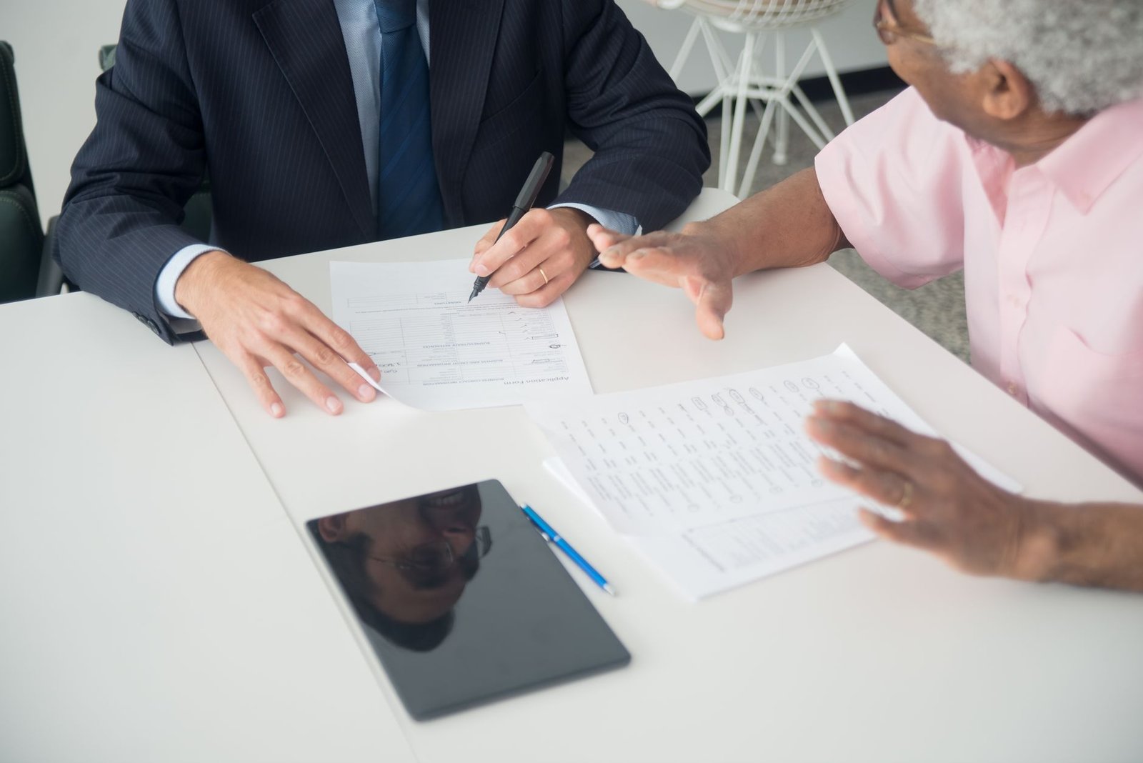 A veteran and an advisor comparing asbestos trust fund vs VA benefits paperwork across a desk